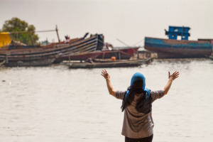 Indonesische vrouw met geheven handen voor rivier
